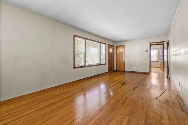 spare room featuring ornamental molding and light wood-type flooring