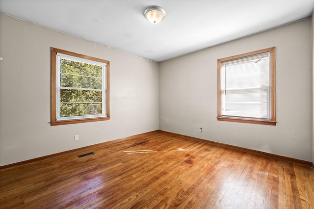 unfurnished room with hardwood / wood-style floors