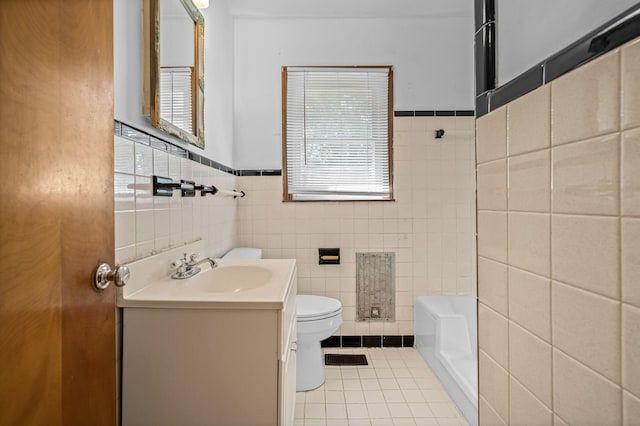 bathroom featuring tile patterned flooring, vanity, toilet, and tile walls