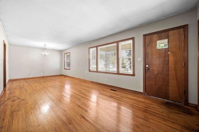 entryway featuring light wood-type flooring and a notable chandelier