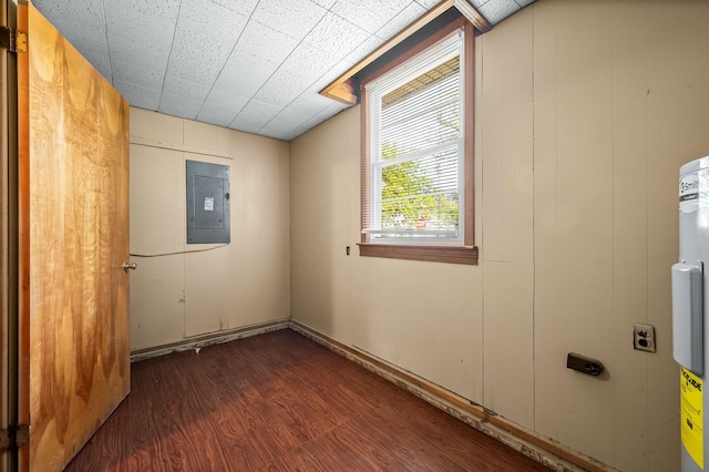 empty room featuring electric panel and dark hardwood / wood-style flooring