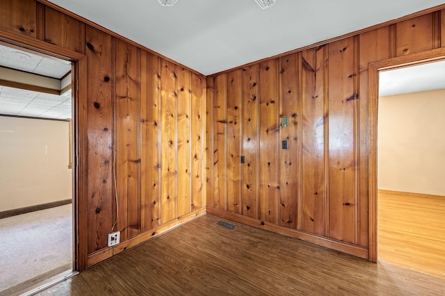 unfurnished room with wood walls and hardwood / wood-style flooring