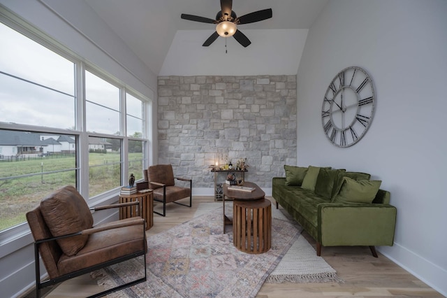 living room featuring plenty of natural light, light wood-type flooring, and lofted ceiling