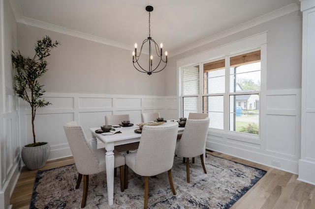 dining area featuring ornamental molding, hardwood / wood-style flooring, plenty of natural light, and a notable chandelier