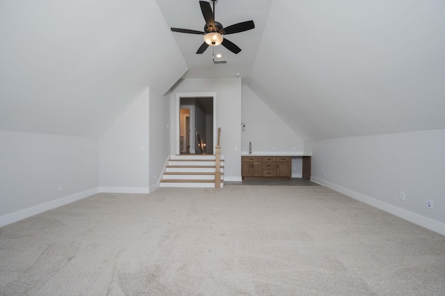 additional living space with ceiling fan, light colored carpet, and vaulted ceiling