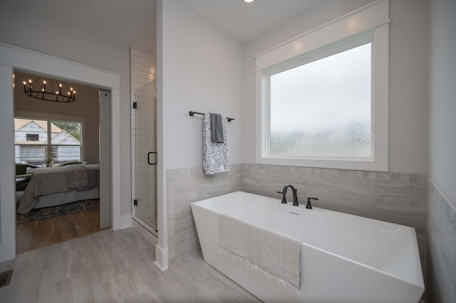 bathroom with plus walk in shower and an inviting chandelier