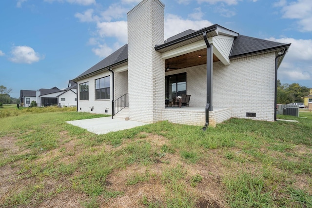 back of house featuring central air condition unit, a patio area, and a yard