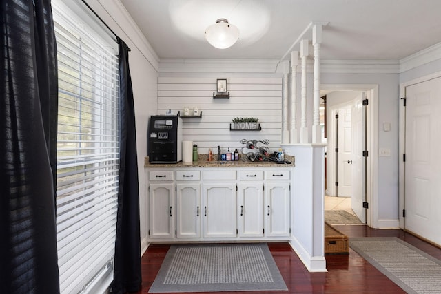 bar with dark hardwood / wood-style floors, white cabinetry, and crown molding