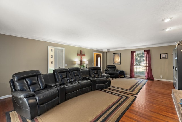 cinema room with a textured ceiling, crown molding, and dark wood-type flooring