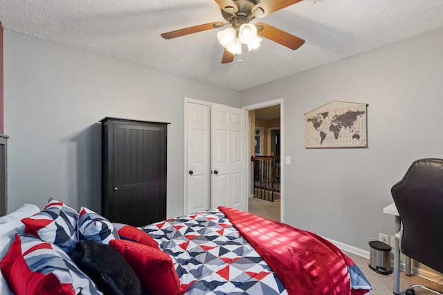 bedroom featuring carpet flooring, a textured ceiling, and ceiling fan