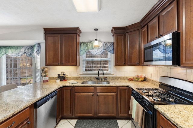 kitchen featuring a wealth of natural light, stainless steel appliances, hanging light fixtures, and sink