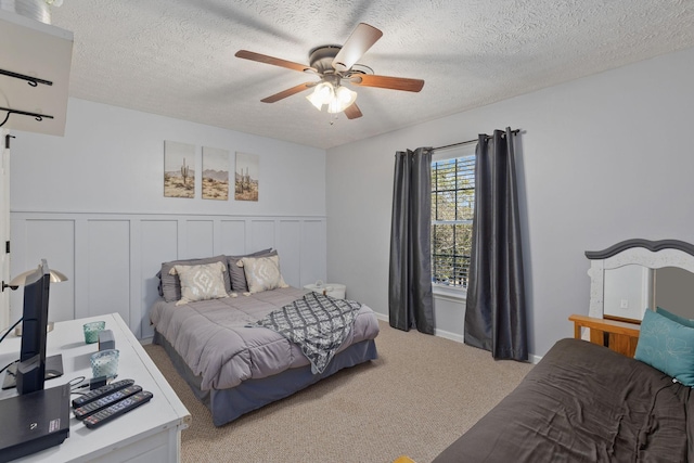 carpeted bedroom featuring ceiling fan and a textured ceiling