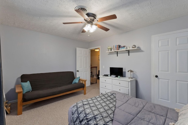 carpeted bedroom featuring a textured ceiling and ceiling fan