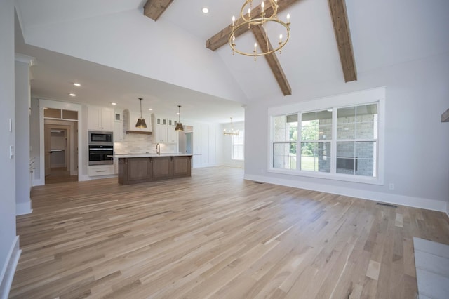 unfurnished living room with beam ceiling, light hardwood / wood-style flooring, high vaulted ceiling, and a notable chandelier