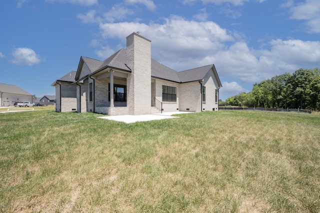 rear view of property with a patio and a lawn