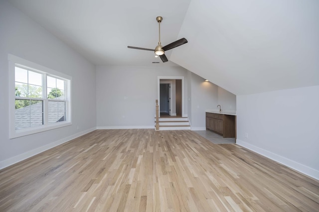 unfurnished living room with light wood-type flooring, ceiling fan, and lofted ceiling