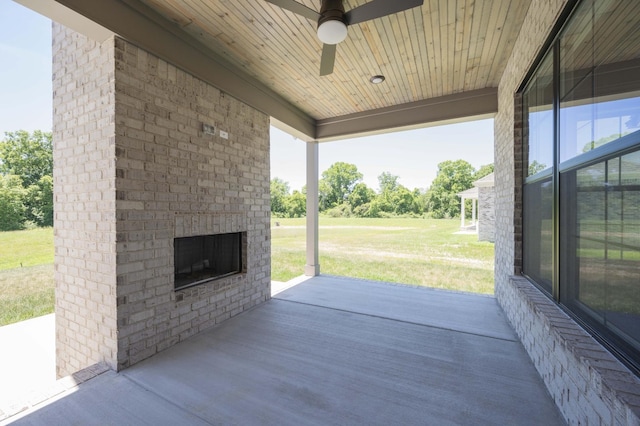 view of patio / terrace featuring an outdoor brick fireplace and ceiling fan