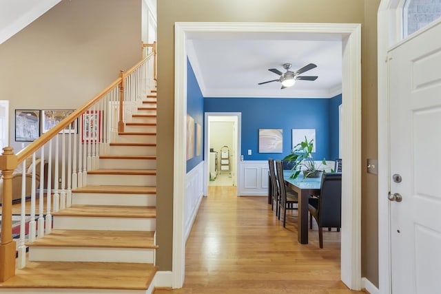 stairs featuring ceiling fan, hardwood / wood-style flooring, and ornamental molding