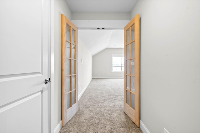 hall with light carpet, french doors, and vaulted ceiling