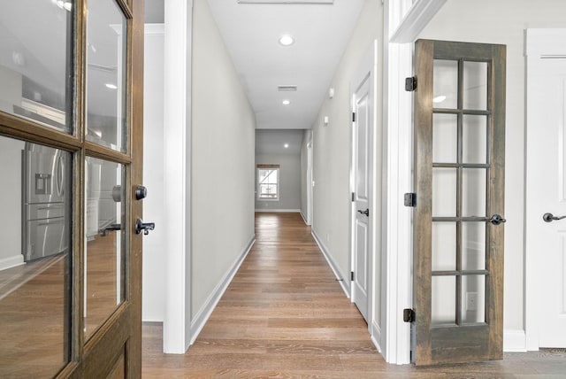 corridor featuring light hardwood / wood-style flooring and french doors