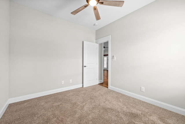 carpeted spare room featuring ceiling fan