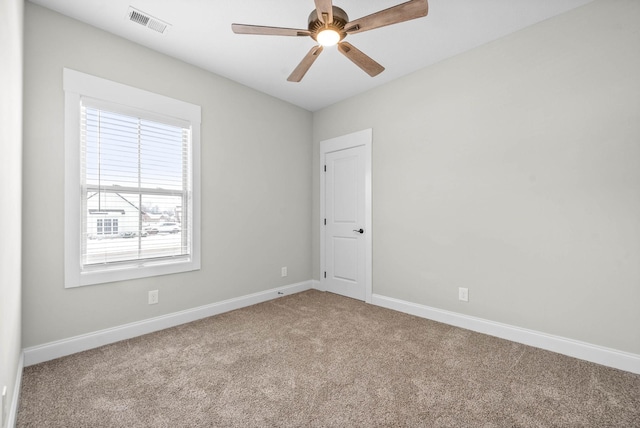 carpeted spare room featuring ceiling fan