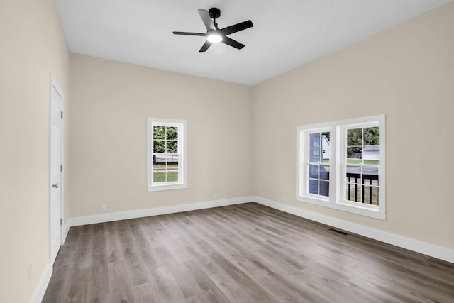 unfurnished room featuring ceiling fan, light wood-type flooring, and a wealth of natural light