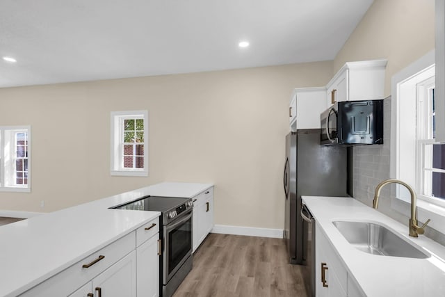 kitchen featuring white cabinets, light wood-type flooring, sink, and appliances with stainless steel finishes