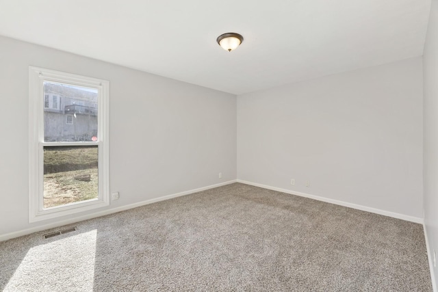 carpeted spare room featuring plenty of natural light