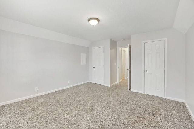 unfurnished bedroom with light carpet and lofted ceiling