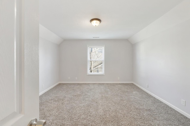 empty room with carpet and vaulted ceiling