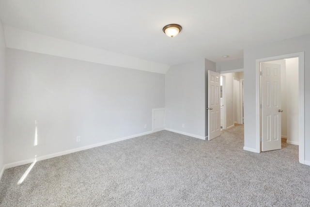 unfurnished bedroom with light colored carpet and lofted ceiling