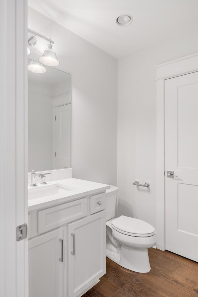 bathroom featuring vanity, toilet, and wood-type flooring