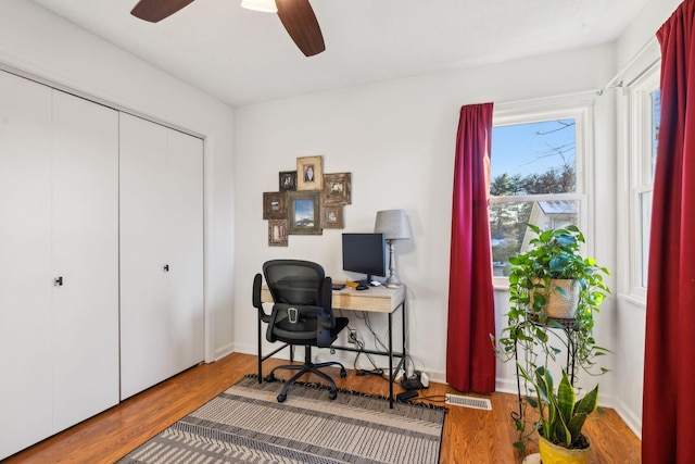 office with hardwood / wood-style flooring and ceiling fan