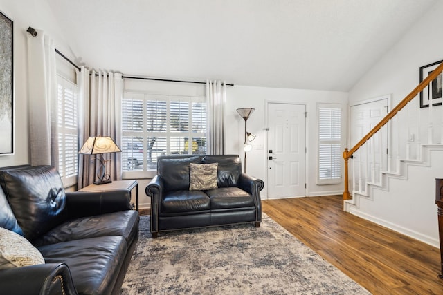 living room featuring wood-type flooring and vaulted ceiling