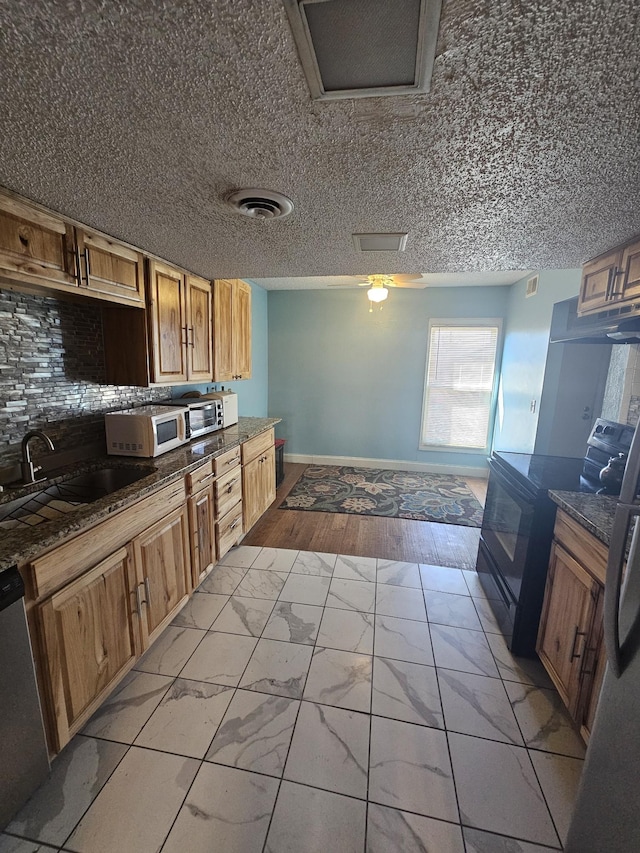 kitchen with decorative backsplash, sink, and appliances with stainless steel finishes