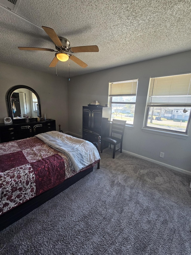 carpeted bedroom with ceiling fan and a textured ceiling