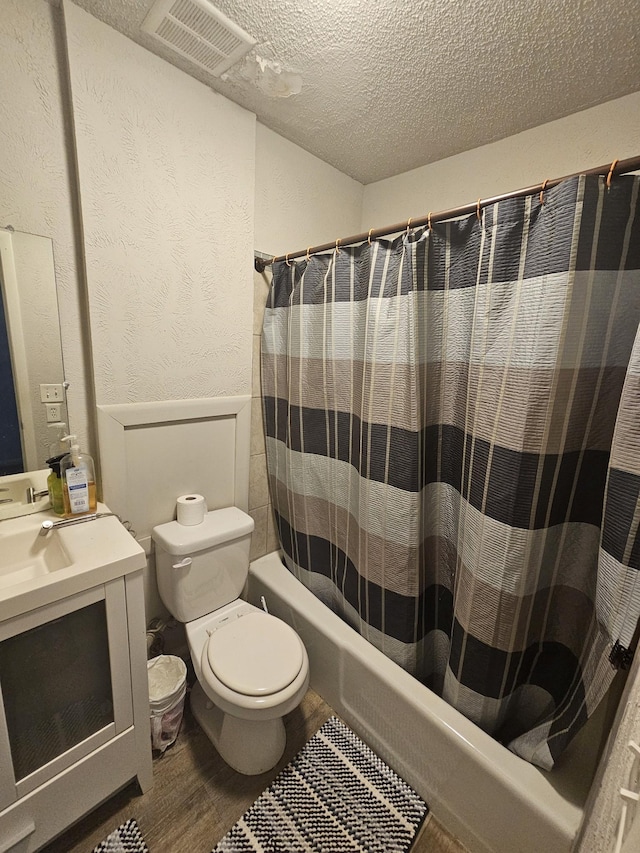 full bathroom with shower / tub combo, vanity, a textured ceiling, wood-type flooring, and toilet