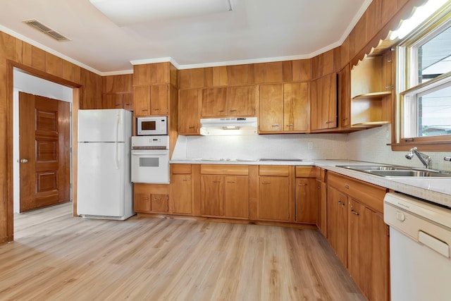 kitchen with decorative backsplash, ornamental molding, white appliances, sink, and light hardwood / wood-style floors