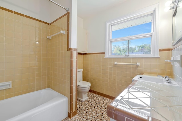 full bathroom featuring tile patterned floors, tiled shower / bath combo, sink, tile walls, and toilet