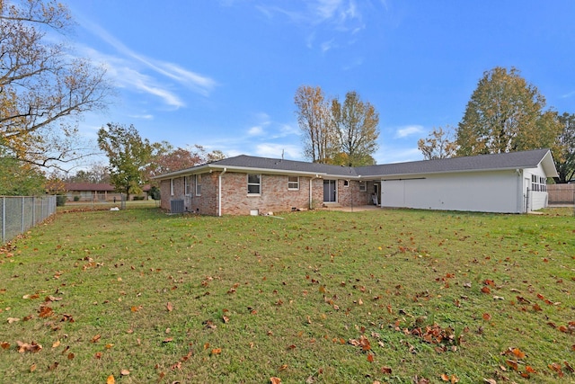 rear view of property with a lawn and central AC