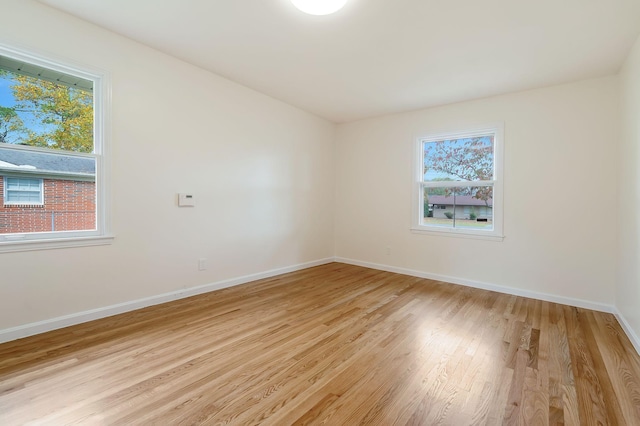 empty room featuring a healthy amount of sunlight and light hardwood / wood-style floors