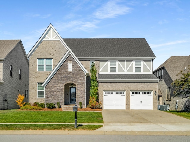 view of front of home featuring a front yard, central AC, and a garage