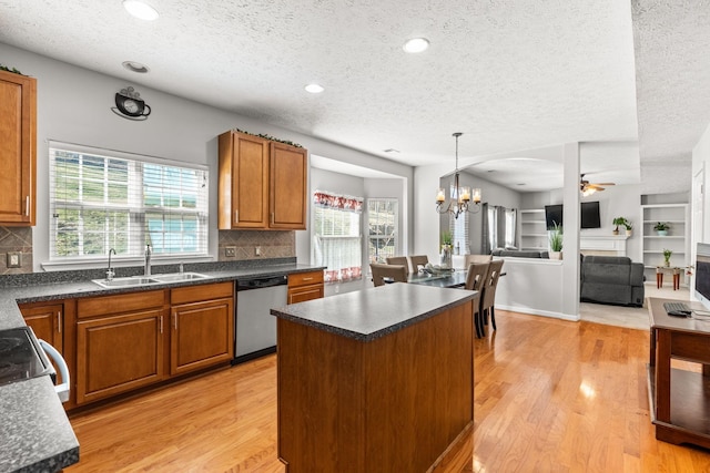 kitchen with stainless steel dishwasher, decorative backsplash, sink, and a textured ceiling