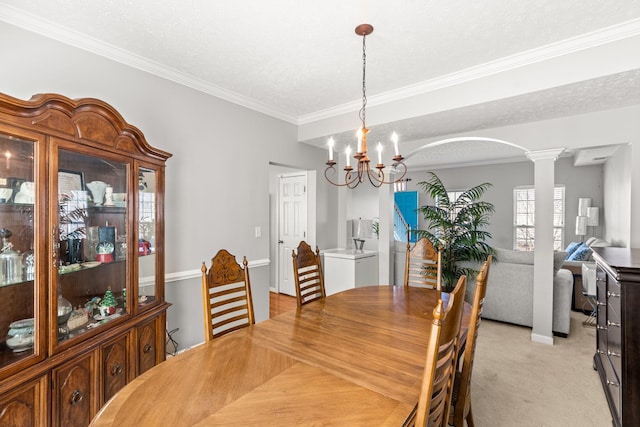 dining space with a textured ceiling, ornate columns, light carpet, and a chandelier