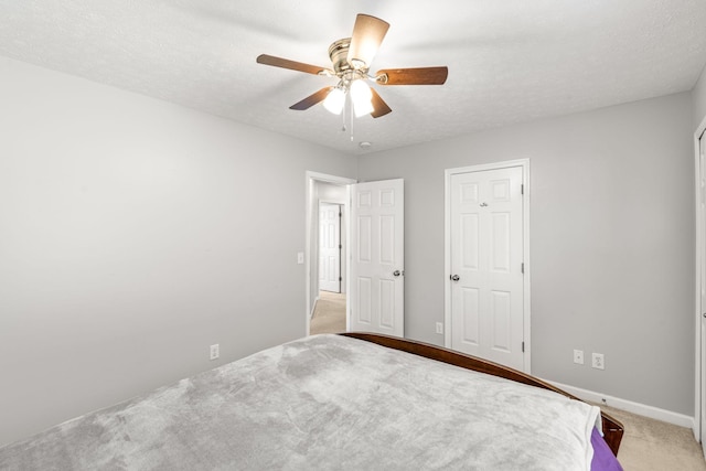 unfurnished bedroom with carpet flooring, a textured ceiling, and ceiling fan