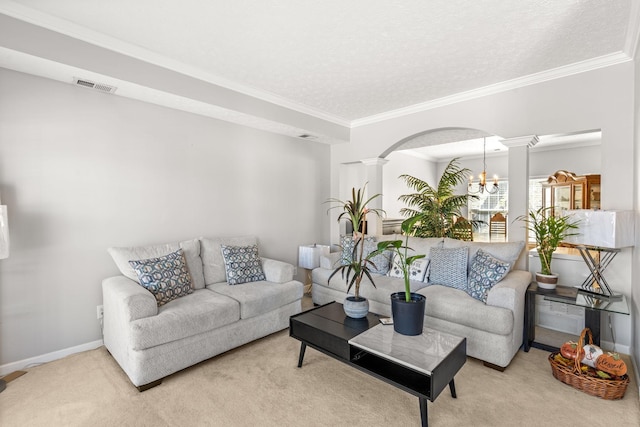 carpeted living room featuring a notable chandelier, ornamental molding, a textured ceiling, and decorative columns