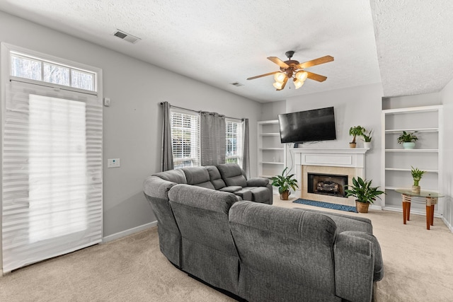 carpeted living room featuring a textured ceiling and ceiling fan