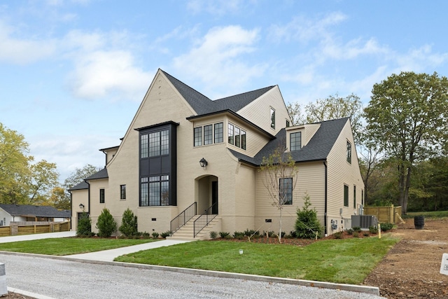 view of front facade with cooling unit and a front yard