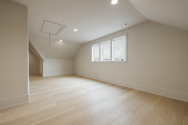 bonus room with vaulted ceiling and light wood-type flooring